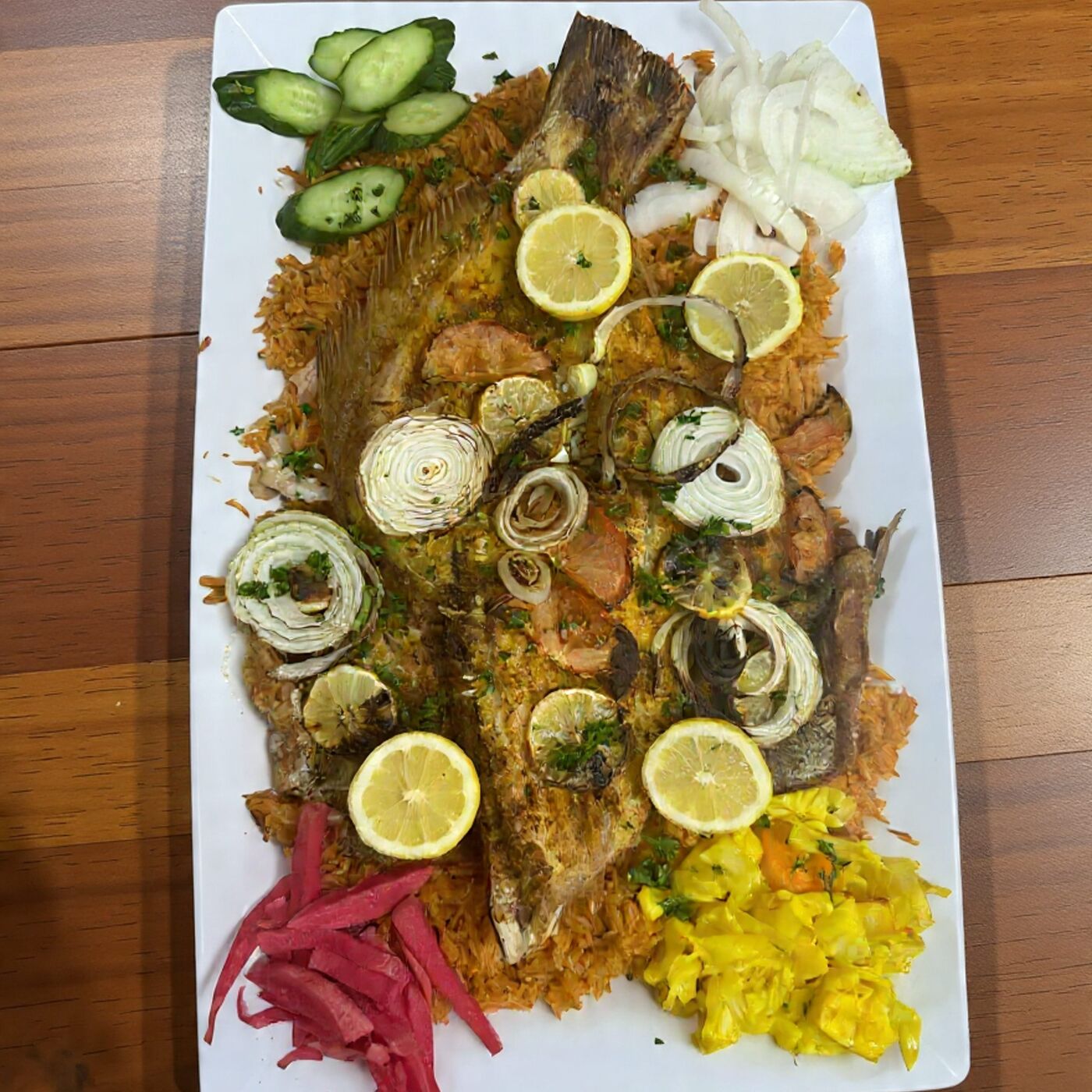 Whole grilled fish on saffron rice with lemon and pickled turnip